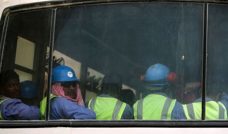 Buitenlandse arbeidsmigranten in Qatar, die werkten aan het al-Wakrah-stadion dat ook voor het WK is gebouwd, in een bus. Beeld AFP