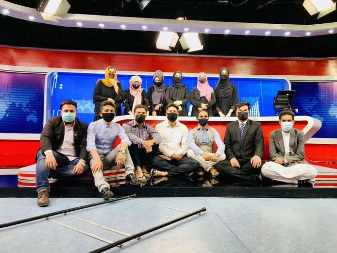 Afghaanse mannelijke presentatoren dragen mondmasker op vrouwelijke collega's te steunen.