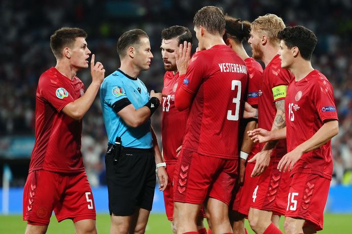Danny Makkelie wordt belaagd door de spelers van Denemarken nadat hij Engeland een strafschop heeft gegeven.