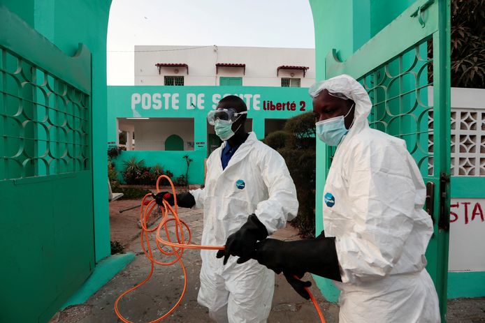 Gezondheidsmedewerkers in Senegal desinfecteren een gezondheidscentrum om de verspreiding van het coronavirus tegen te gaan.