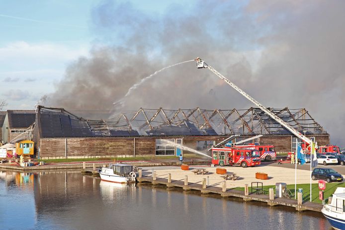 Brandweerlieden blussen de brand in de loodsen bij de IJsselsteinse jachthaven Marnemoende.