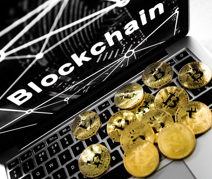 De cryptovaluta Bitcoin en een laptop met het woord blockchain, de technologie achter de Bitcoin.