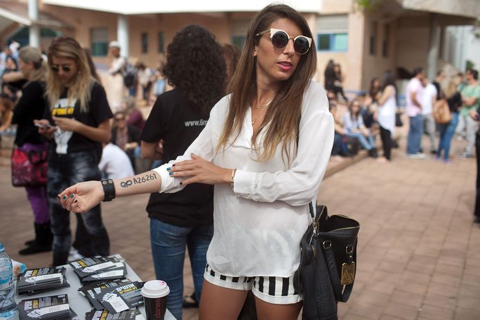 Een jonge Israëlische draagt een tijdelijke tatoeage van een kampnummer als onderdeel van een herinneringscampagne in Tel Aviv