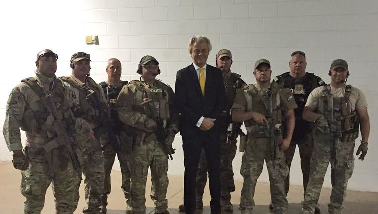 Wilders tussen de agenten in Garland. Beeld AP