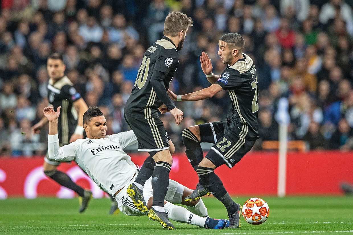 Hakim Ziyech en Lasse Schöne bosten op elkaar als Casemiro een harde tackle op de bal doet. Beeld Guus Dubbelman/ de Volkskrant