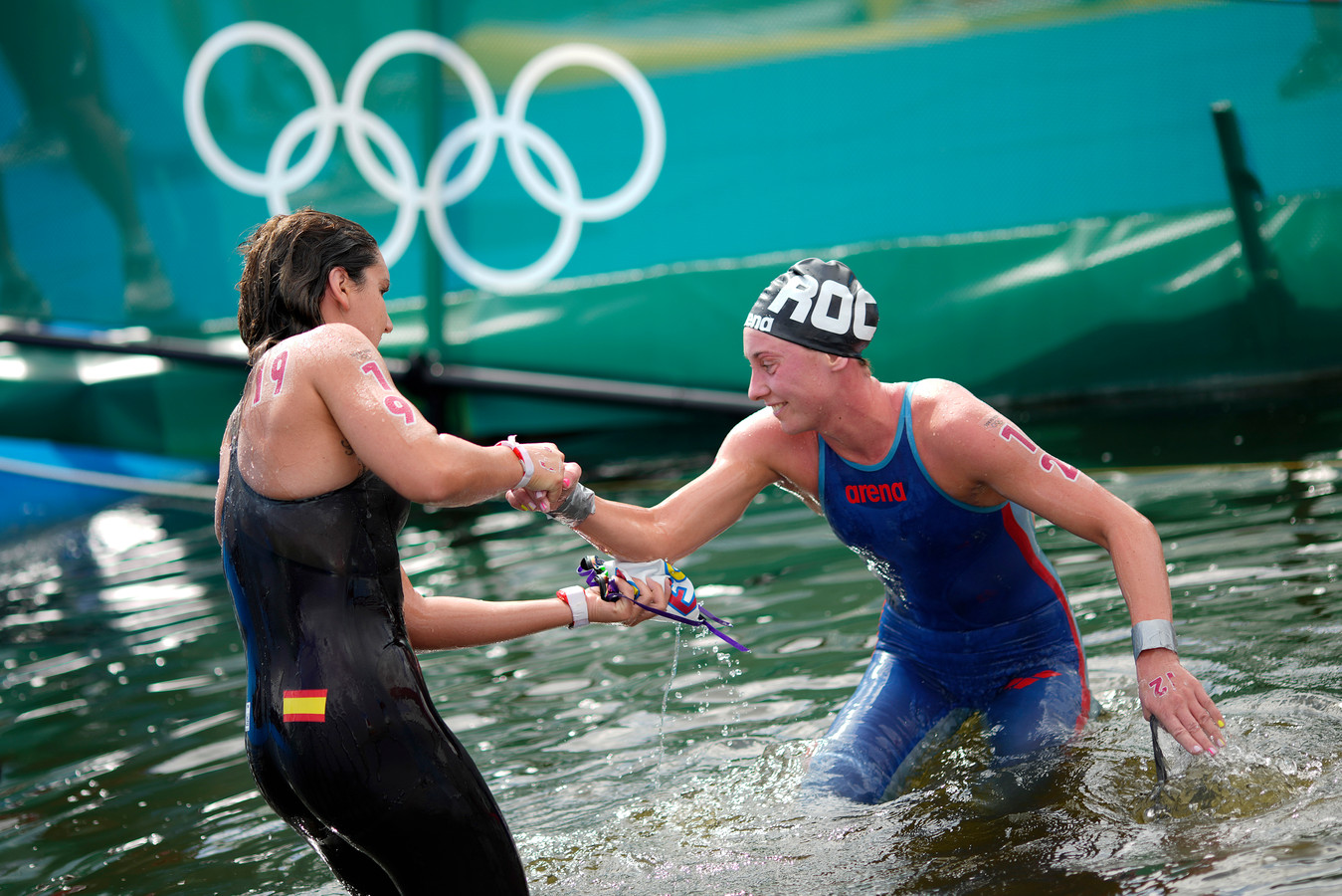 Geef je hand! De Spaanse Paula Ruiz Bravo helpt de Russische Anastasiia Kirpichnikova uit het water na de tien kilometer openwaterzwemmen.
