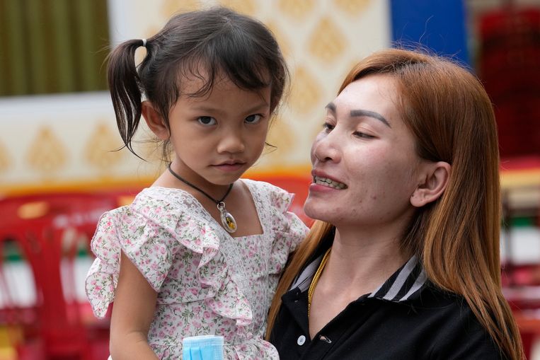 Paweenuch Supolwong, het enige kind dat ongedeerd uit de massamoordaanslag in het kinderdagverblijf is gekomen, met haar moeder Anonpai Srithong. Beeld AP