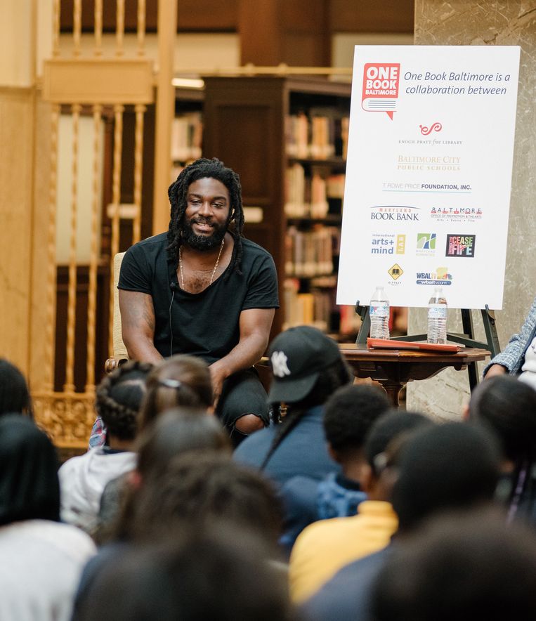 Jason Reynolds praat over zijn boeken met scholieren in Baltimore. ‘Ik kan goed met jongeren praten, ik raak een snaar bij hen. Omdat ik ben en voel zoals zij zijn en voelen.’ Beeld NYT/ANDREW MANGUM