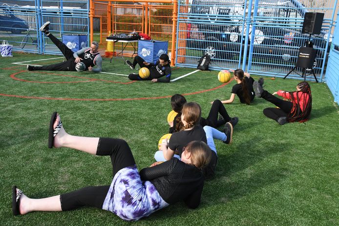 Henk Pieterse en Nasser el Jackson geven ter ere van de heropening van de Blauwe Voetbalkooi een clinic aan leerlingen van de naburige Brede Bossche School in de wijk De Haren.