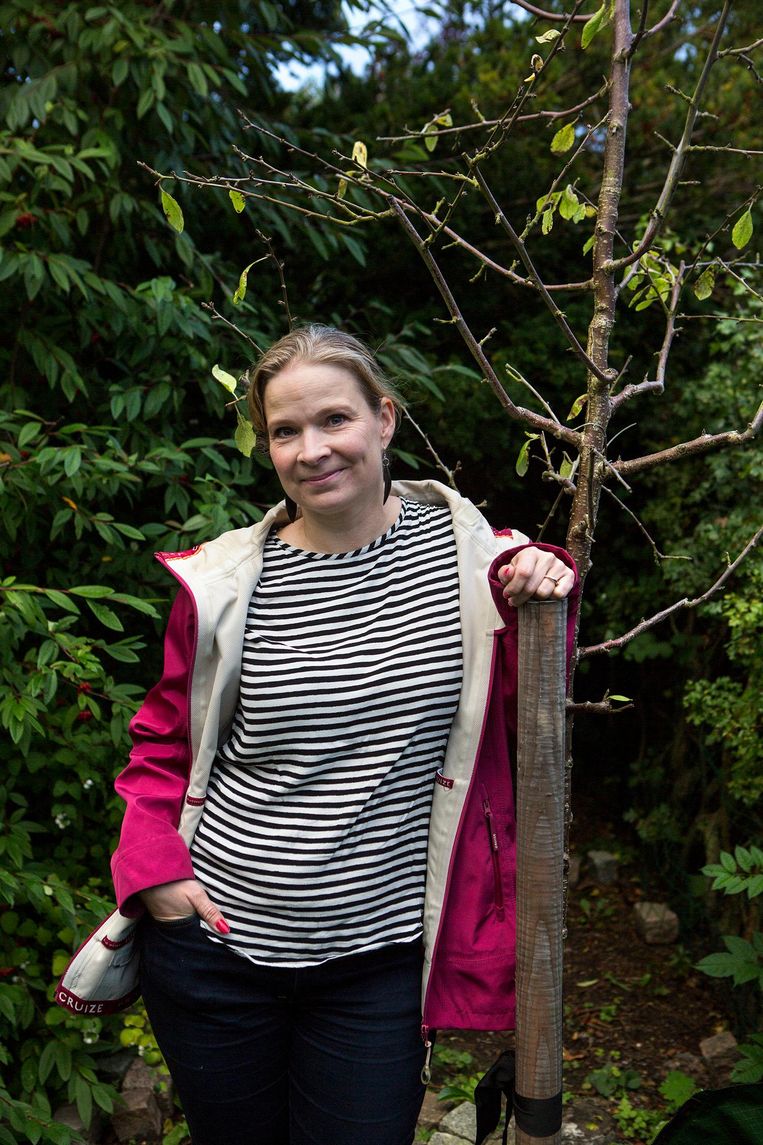 Rikke Berlin Rasmussen in haar tuin met één van haar drie 'adoptiefruitbomen'. Beeld Julius Schrank / de Volkskrant