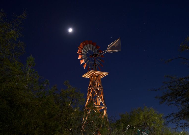 De maan en de planeten Saturnus en Jupiter zijn te zien boven een windmolen in Las Vegas. Beeld AFP
