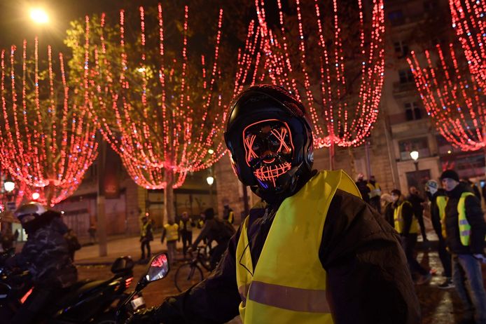 Een gemaskerde demonstrant bij de Arc de Triomphe zaterdag.