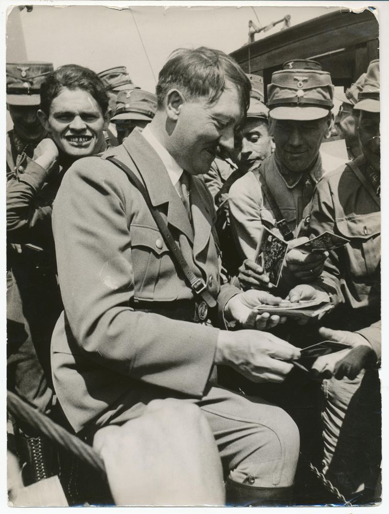Herrenchiemsee, 3 juli 1933. Na afloop van de Reichsführertag op een klein eiland in de Beierse Chiemsee deelt Hitler foto’s met handtekening uit aan bewonderaars.

 Beeld Fotograaf onbekend, NIOD, Beeldbank WO2