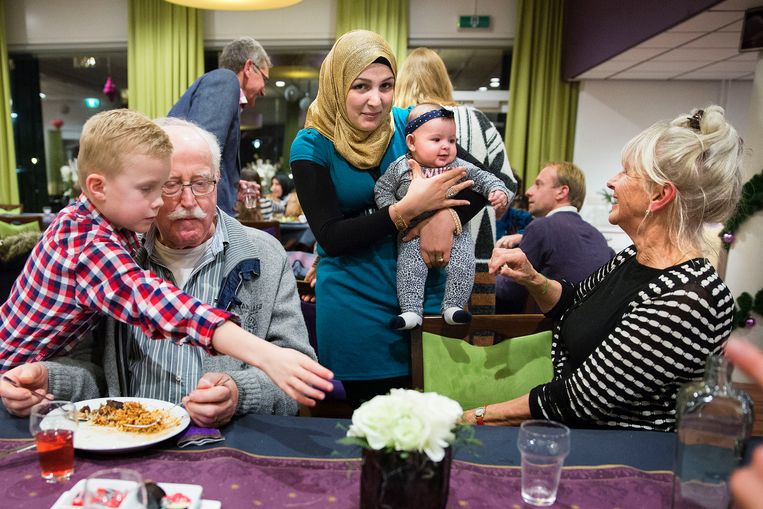 Nieuwe inwoners van Cromstrijen, vluchtelingen uit Syrië en Eritrea, koken op 17 december voor hun dorpsgenoten. Beeld Arie Kievit / de Volkskrant