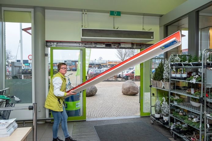 De kap boven de deur is eraf geslagen door de luchtdruk van de explosie. Medewerkster Bea ruimt de kap op.