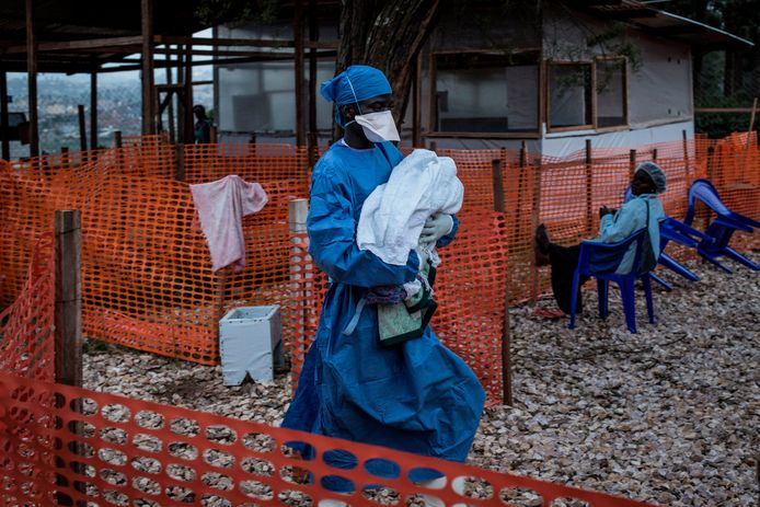 Een dokter draagt een vierjarig kindje dat besmet is met het ebolavirus.