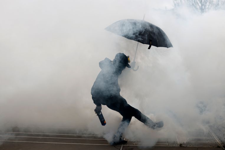 Een demonstrant donderdag in Nantes, terwijl hij een cilinder met traangas wegschopt.  Beeld AP