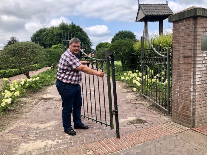 Voorzitter Alfons Steggink schudt vol onbegrip zijn hoofd als hij naar de vernielde toegangspoort van het kerkhof aan het Oldenzaalsvoetpad in Ootmarsum kijkt.