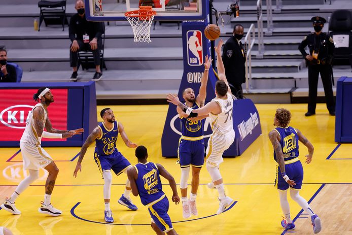 Luka Doncic probeert te scoren met Stephen Curry als hinderlaag.