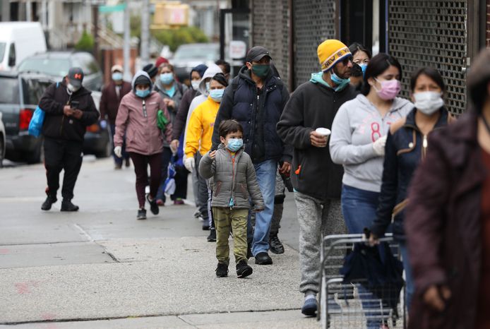 Mensen schuiven aan in een lange rij in New York in de hoop een voedselpakket te krijgen.