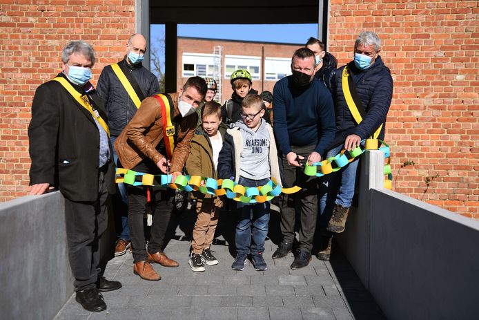 Burgemeester Bert De Wit (CD&V) knipt het lintje door met een leerling.