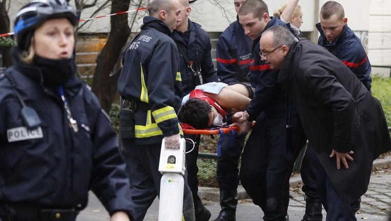 Hulpverleners brengen een slachtoffer weg na de aanslag op het weekblad Charlie Hebdo in Parijs. Beeld REUTERS