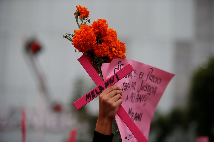 Vrouw houdt kruis omhoog met naam van slachtoffer van femicide in Mexico-Stad, Mexico.