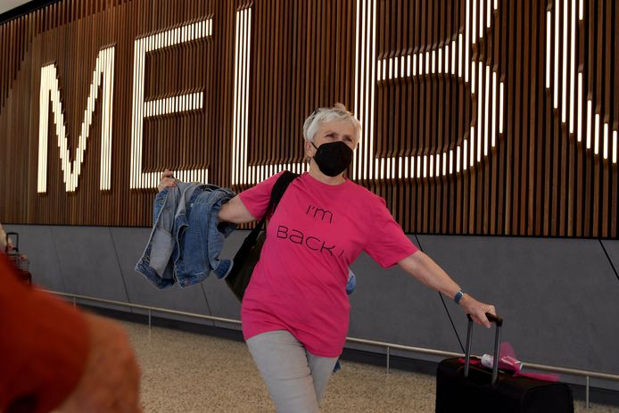 Een vrouw met op haar -shirt de tekst 'I'm Back', 'ik ben terug', komt aan op de luchthaven van Melbourne.