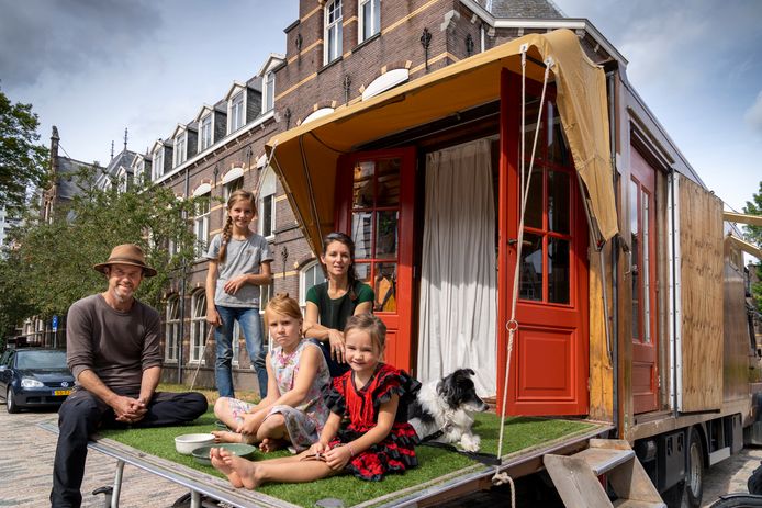 Daan Zuijderwijk en Maaike Vergouwe staan met hun kampeerbus die een huiselijk aanzien heeft op het voormalige GZG-terrein. Van links naar rechts: Daan Zuijderwijk, Fenna,  Alba, Maaike Vergouwe Isolde en hond Nan.