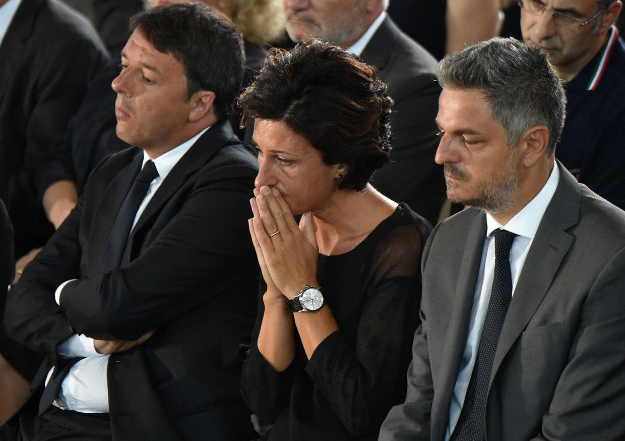 Premier Matteo Renzi (l) en zijn vrouw Agnese (m) tijdens de herdenking van de slachtoffers. Beeld afp