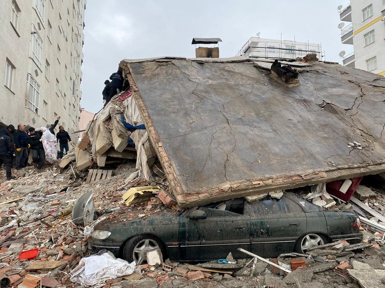 Inwoners van de Turkse stad Diyarbaki zoeken tussen het puin van een ingestort gebouw op 6 februari 2023.  Beeld REUTERS
