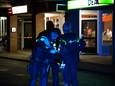Agenten onderzoeken de schietpartij op straat voor snackbar De Methen aan het Tortonaplein in Zevenaar.