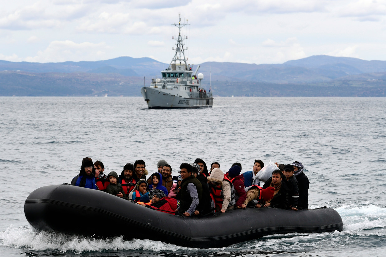 Een rubberboot met migranten met op de achtergrond een schip van Frontex in februari 2020. Beeld AP. Beeld AP