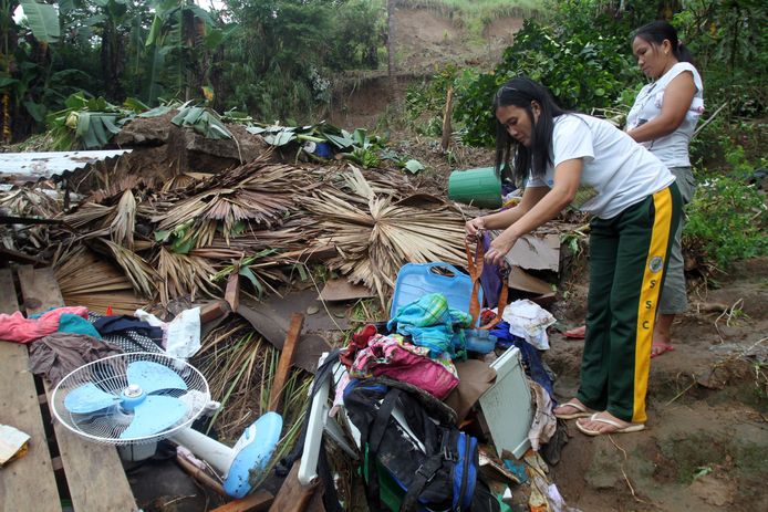 Vrouwen zoeken nog bruikbare spullen uit uit hun verwoeste huizen in Bulan, in de provincie Sorsogon.