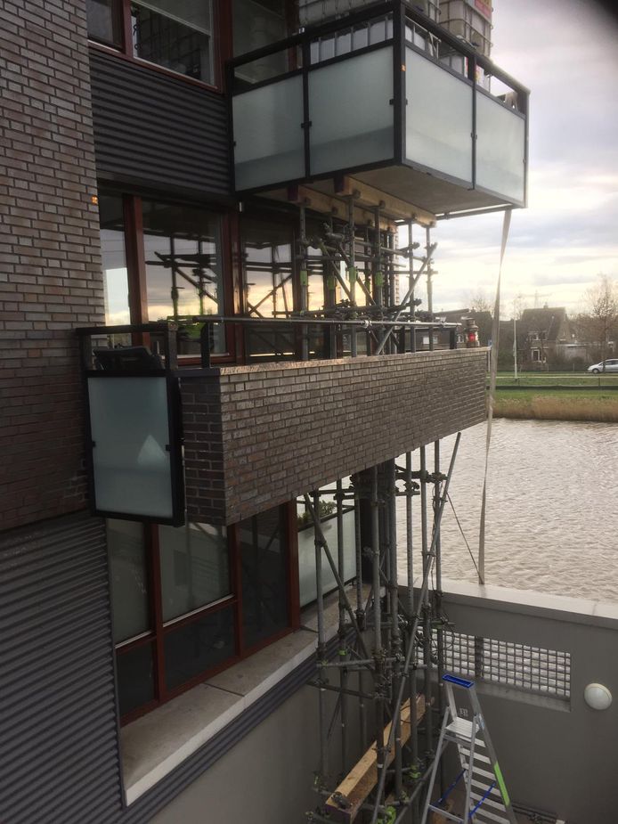 Balkons in de wijk Kroeten in de Haagse Beemden ondergaan een proef met zware belasting, bovenin zijn de vaten met water nog net te zien.