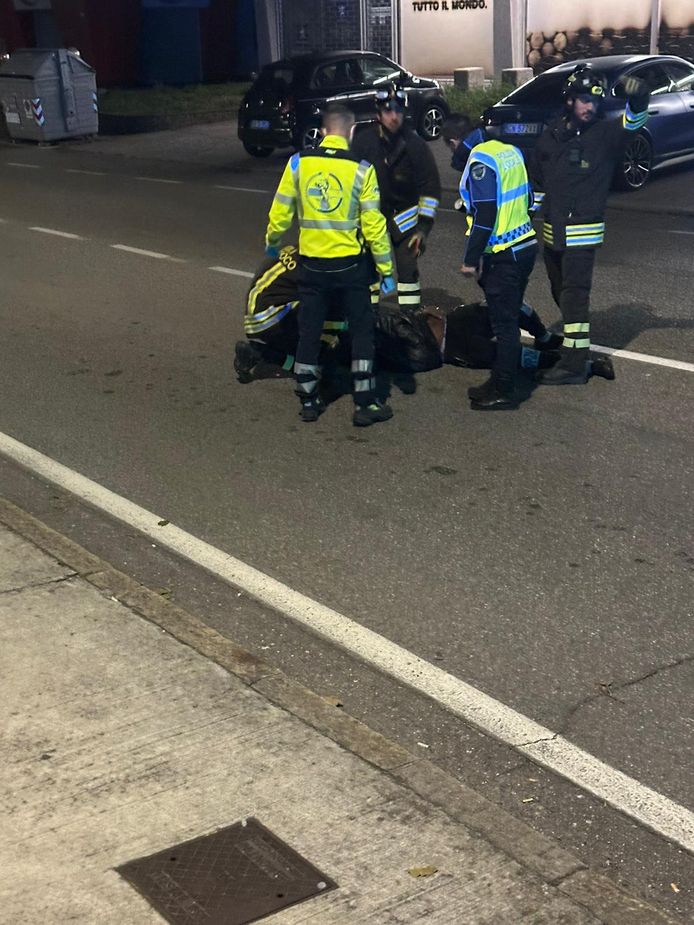 Balotelli ligt op de grond na z'n ongeval, met naast hem enkele agenten en hulpverleners.