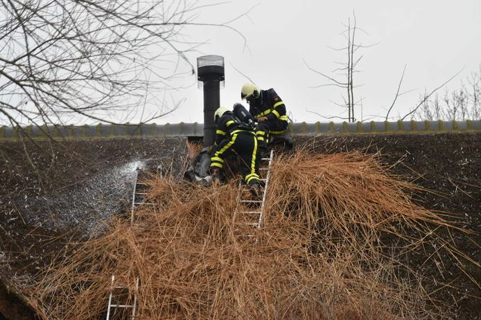 Schoorsteenbrand bij een rieten dak.