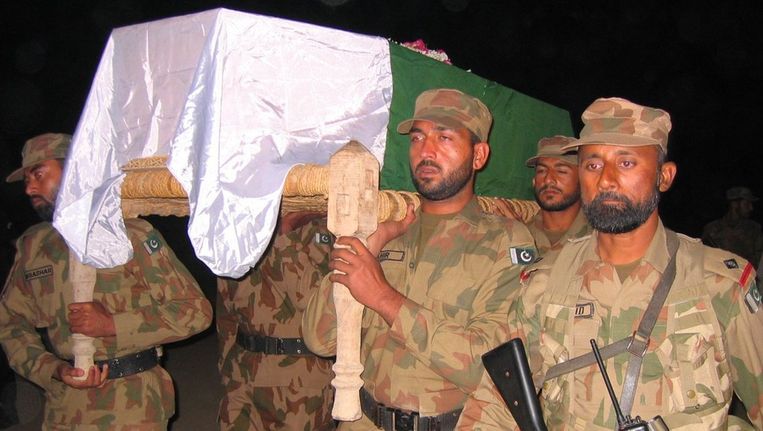 Pakistaanse militairen dragen de kist van een collega die sneuvelde tijdens het NAVO-bombardement. Beeld epa