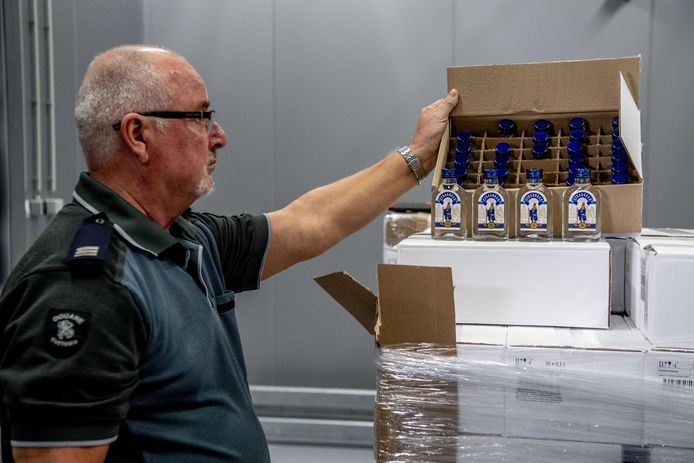 Een Nederlandse douanier bij de in beslag genomen lading. De douane in de Rotterdamse haven onderschepte een container met 90.000 flessen wodka. De lading was mogelijk bestemd voor de Noord-Koreaanse leider Kim Jong-un en zijn legerleiding.