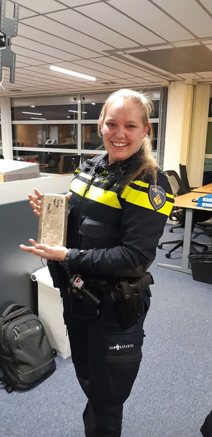 Een agent van de politie Utrecht pronkt met de gevonden goudstaaf