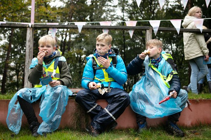 Steven Poolman en de broers Tim en Luuk Prins van scouting Dedemsvaart verorberen hun dikke koek.