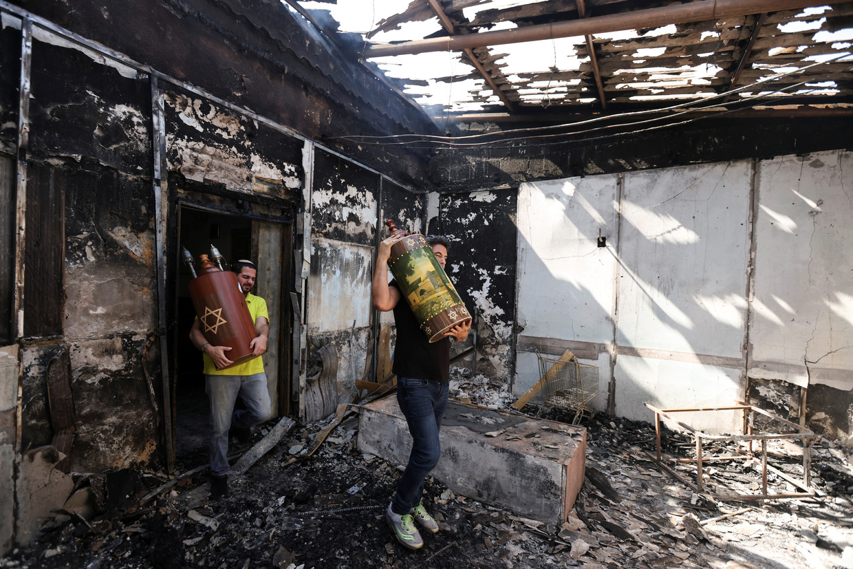 Joden halen thorarollen uit een synagoge in Lod die door Arabieren in brand is gestoken. Beeld REUTERS