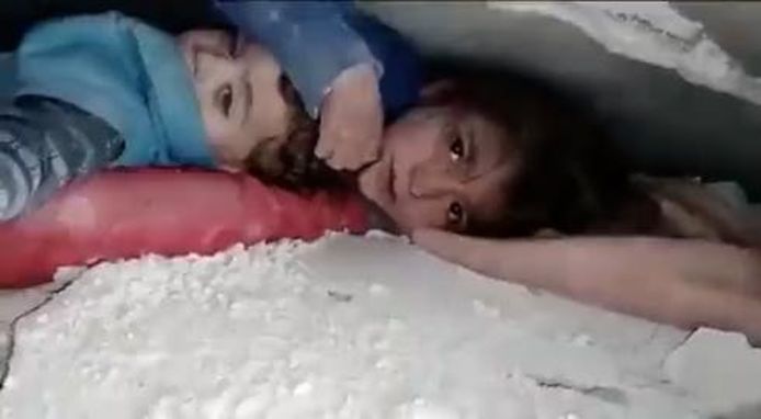 De Syrische Mariam beschermt haar kleine broertje urenlang tegen stof en puin na de zware aardbeving in Syrië en Turkije.