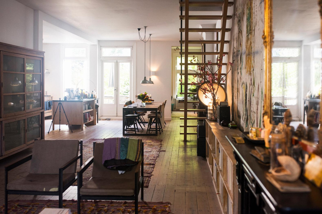 Verbouwing. 'Toen ik hier zo'n jaar of twintig geleden kwam wonen, was het goed zoals het was: ik heb al mijn rare spullen erin gezet, en klaar. Later hebben we verbouwd. De open keuken, de grote portalen, al het oude glas-in-lood eruit. Het voelt nu lichter en ruimer, maar de sfeer van honderd jaar geleden is bewaard gebleven.' Beeld Dim Balsem