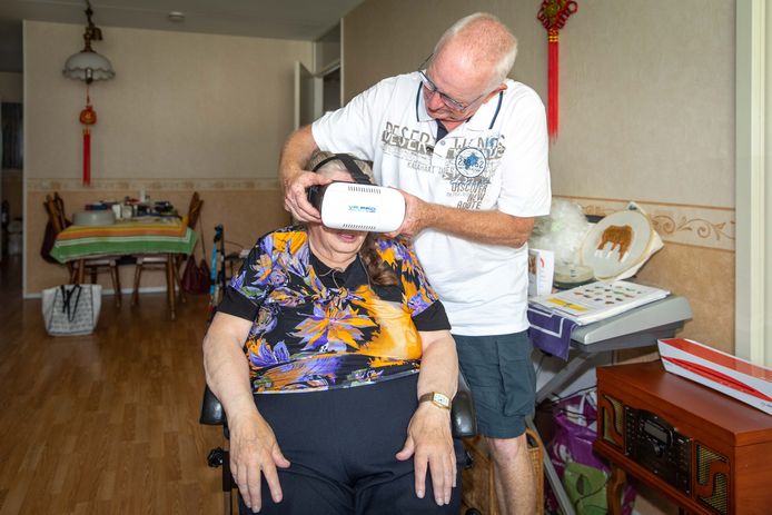 Vrijwilliger Wim Dongen zet de VR-bril op bij Cobie van der Velden.