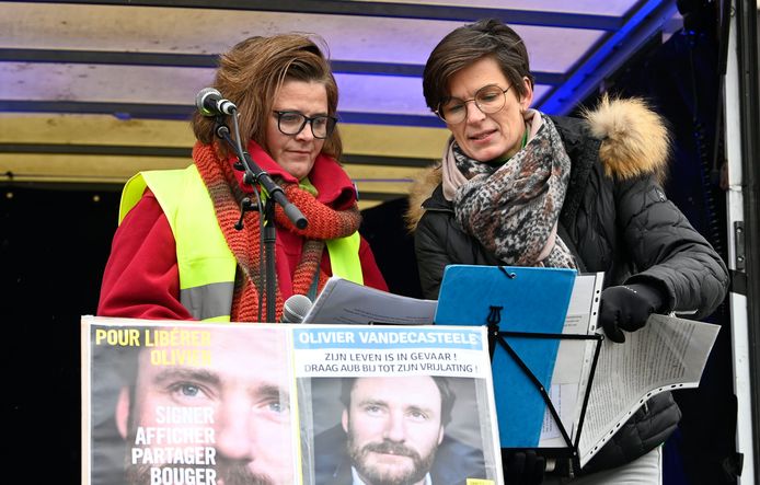 Virginie (links) en Nathalie, de zussen van Olivier Vandecasteele, spraken de menigte toe op het Brusselse Albertinaplein.
