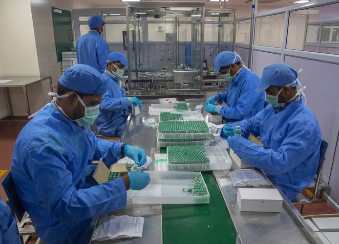 Werknemers van het Serum Institute of India verpakken vaccins van Covishield.