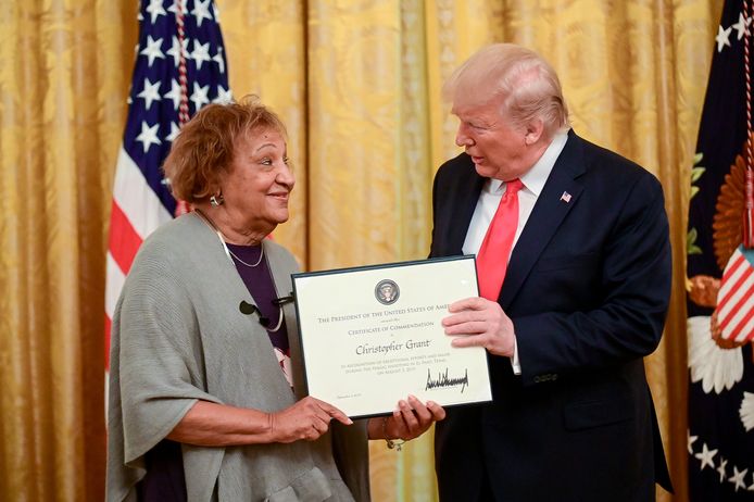 Donald Trump overhandigt een huldigingscertificaat aan Minnie Grant, moeder van de even aangehouden Christopher Grant.