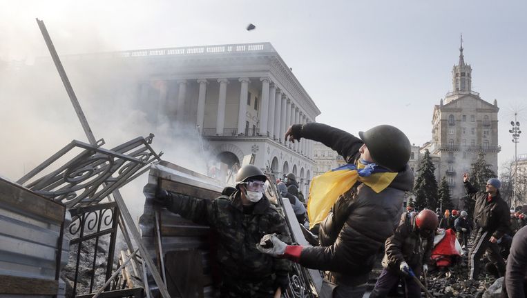 Een anti-regeringsdemonstrant in Kiev gooit stenen richting de oproerpolitie. Beeld ap