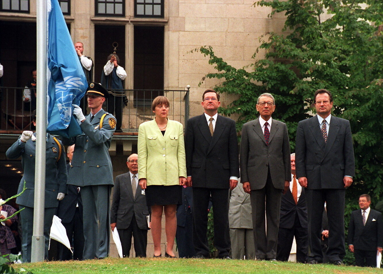 Angela Merkel draagt een geel jasje in 1996.